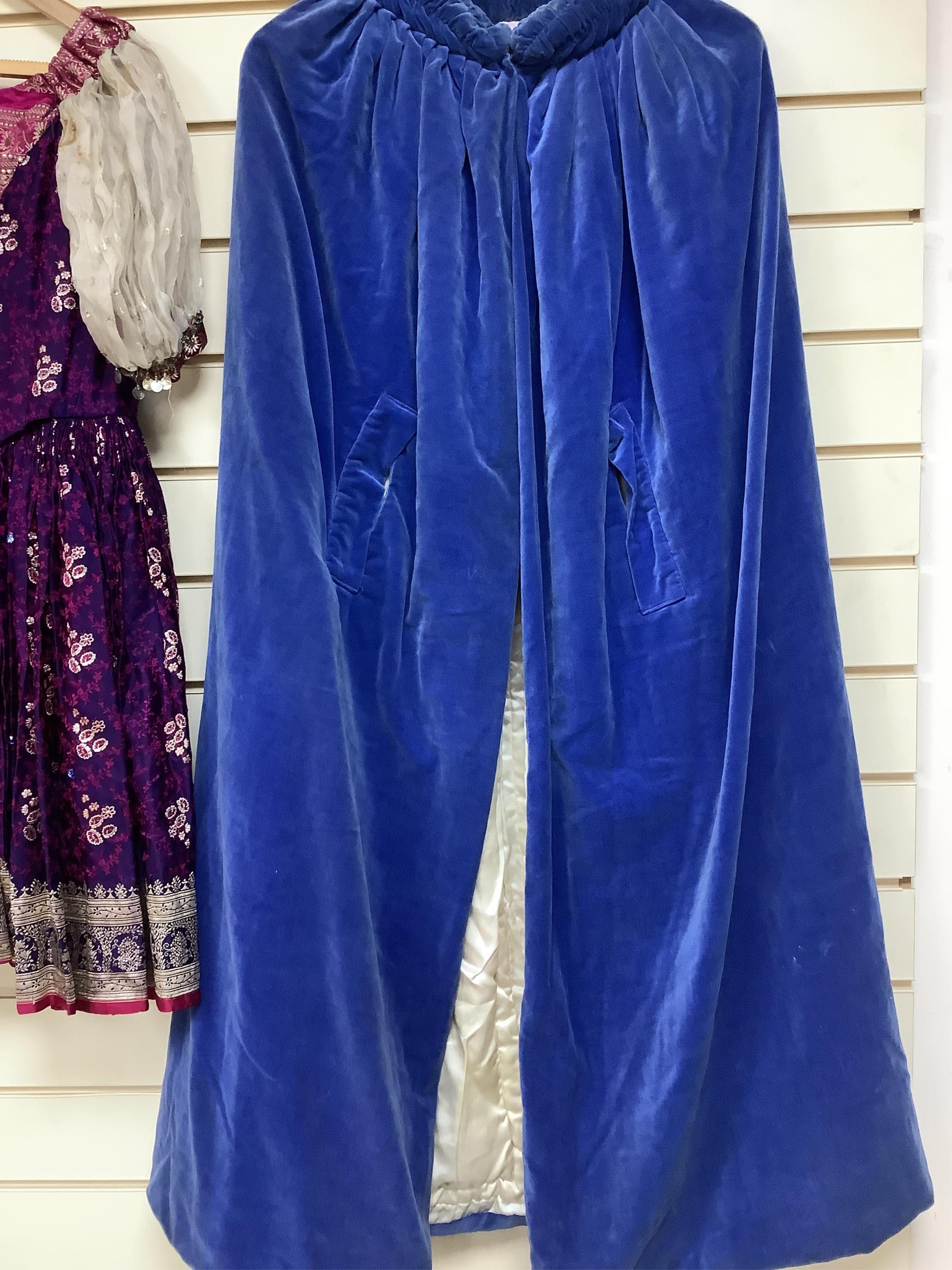 A child’s theatrical brocade dress and a lady’s blue velvet, cream and silk-lined cape, labelled Jenners, Edinburgh- 116cm long.